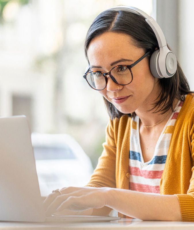young woman on laptop with headphones on