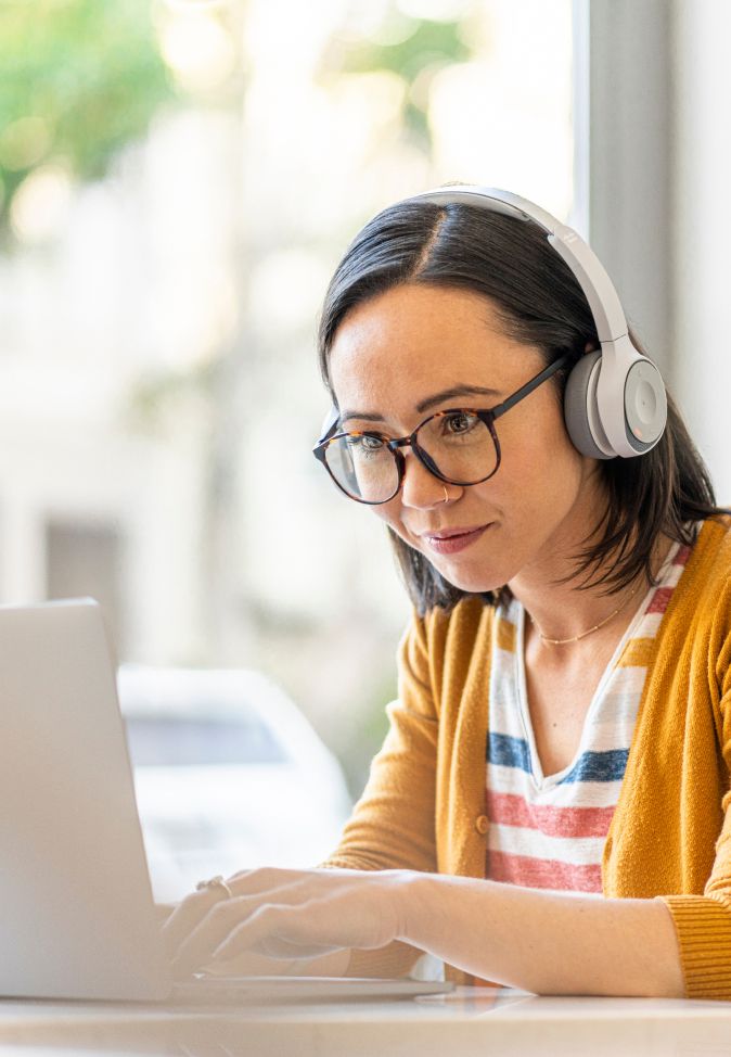 young woman on laptop with headphones on