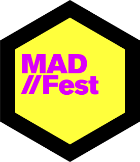 The MAD//Fest logo. A bright yellow octagon with the word MAD//Fest inside in hot pink.