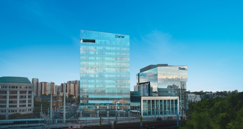 The Charter Communications headquarters photographed from a distance with blue sky in the background.