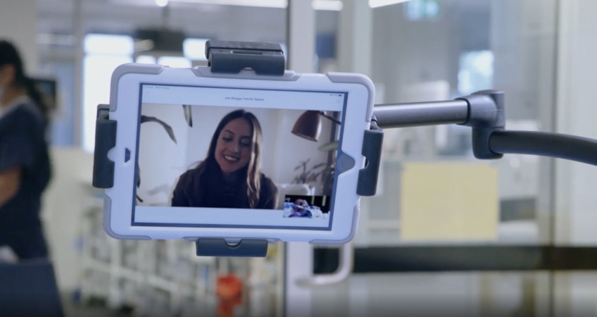 An individual enjoys a virtual visit with a patient in the intensive care unit via Webex.