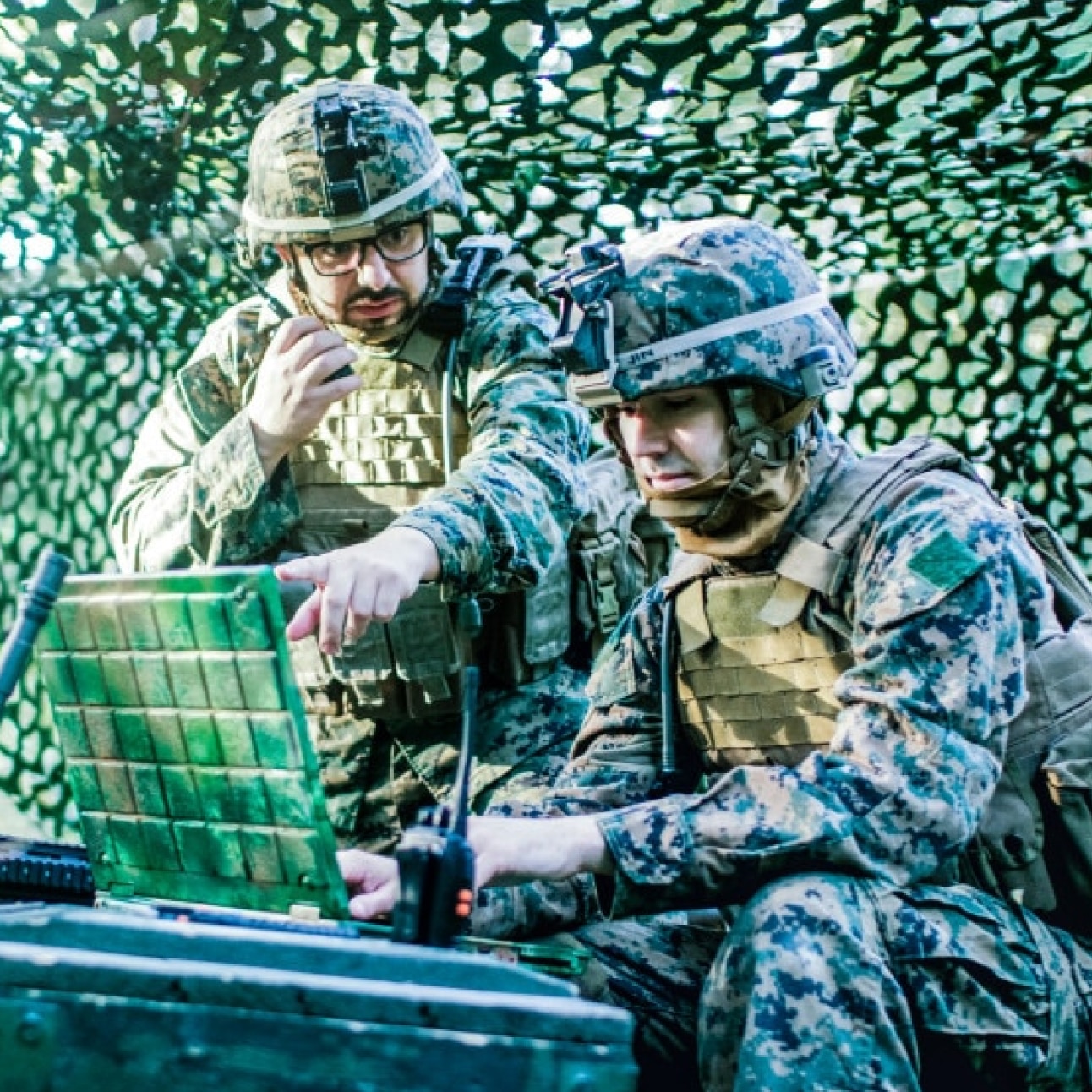 soldiers working on laptop in the field