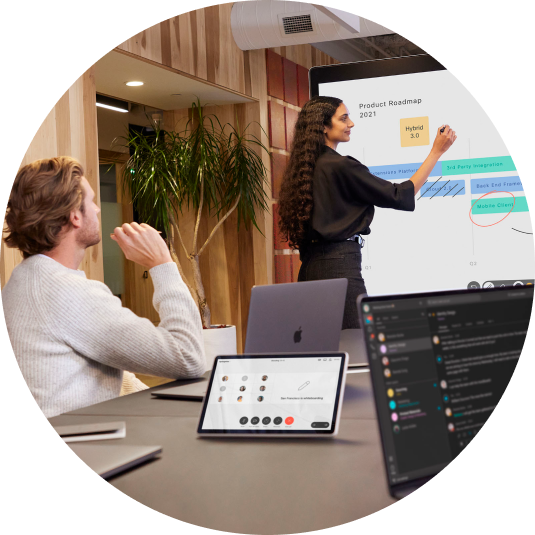 Colleagues in a conference room collaborate, using Webex devices. One person stands at the front, making notes on the screen.