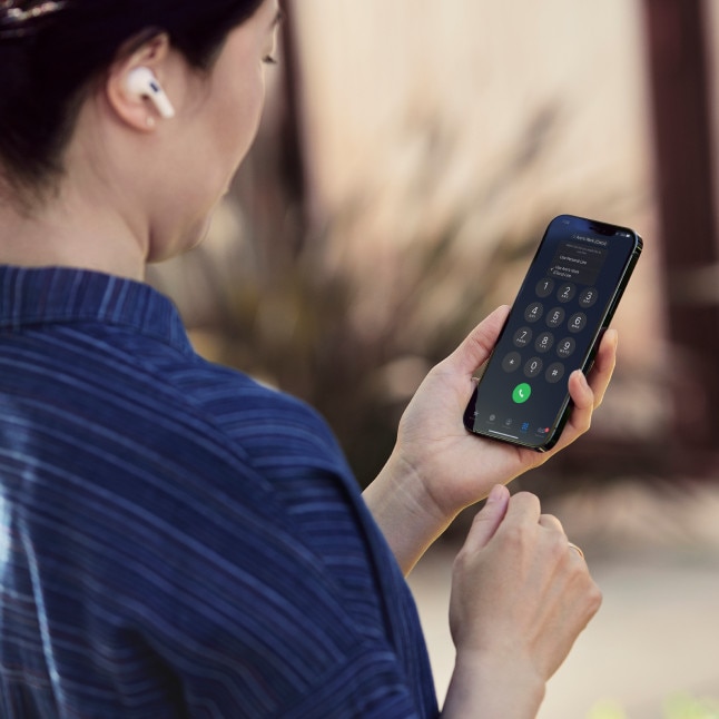 A professional wearing a blue striped shirt collaborates on the go via the Webex App on a mobile phone.