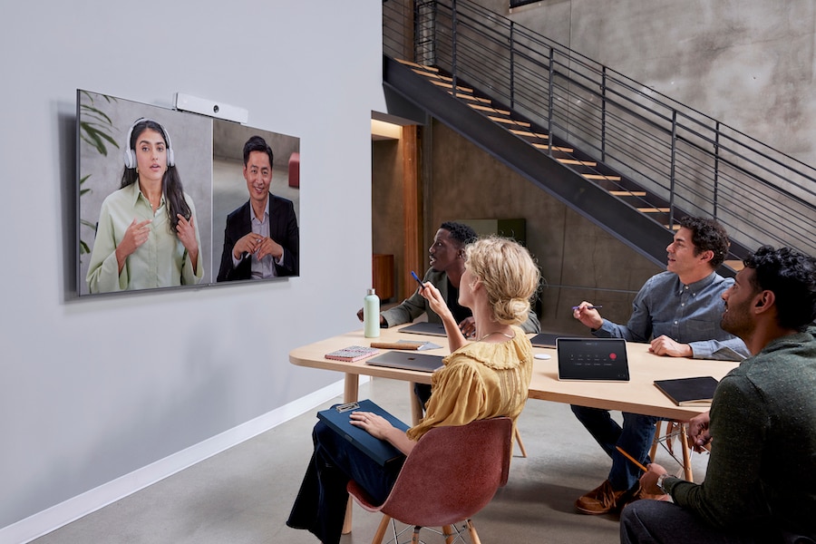 4 colleagues in a conference room video conference with 2 remote colleagues using a Webex Room Bar.