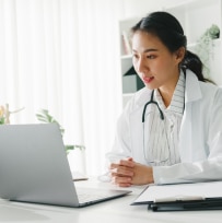 A doctor connects with staff using Webex for telehealth