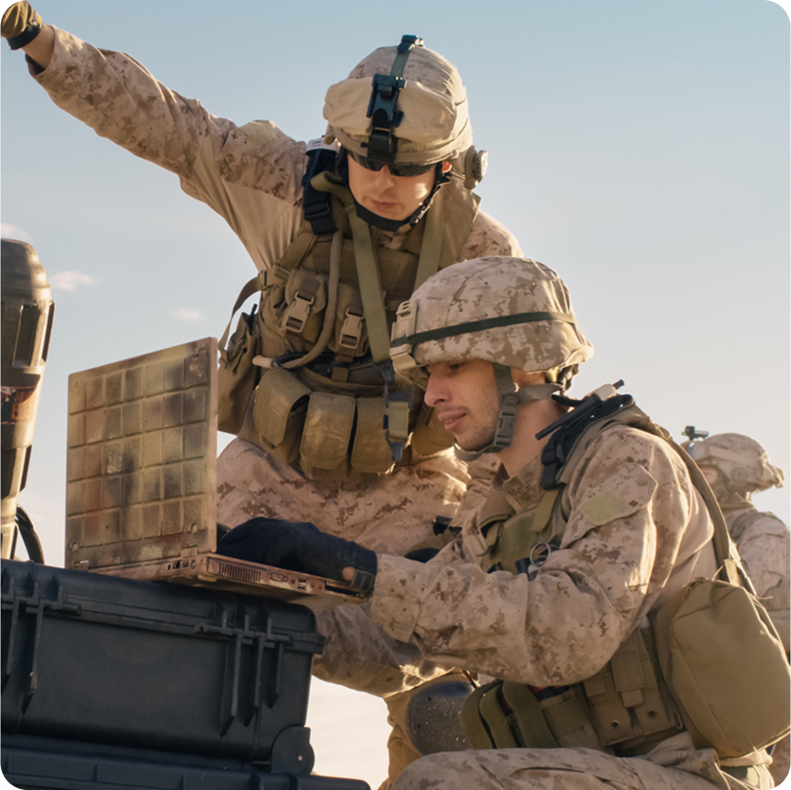 defense employee working on laptop in server room