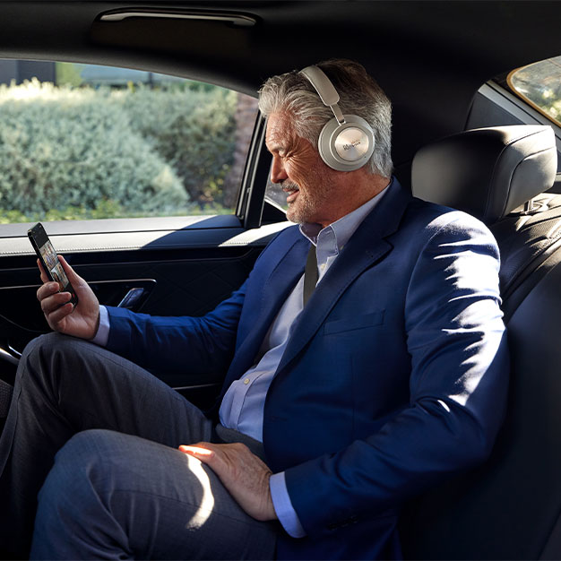 Executive joins video conference in his car using the Webex App on a smartphone and a Cisco headset.