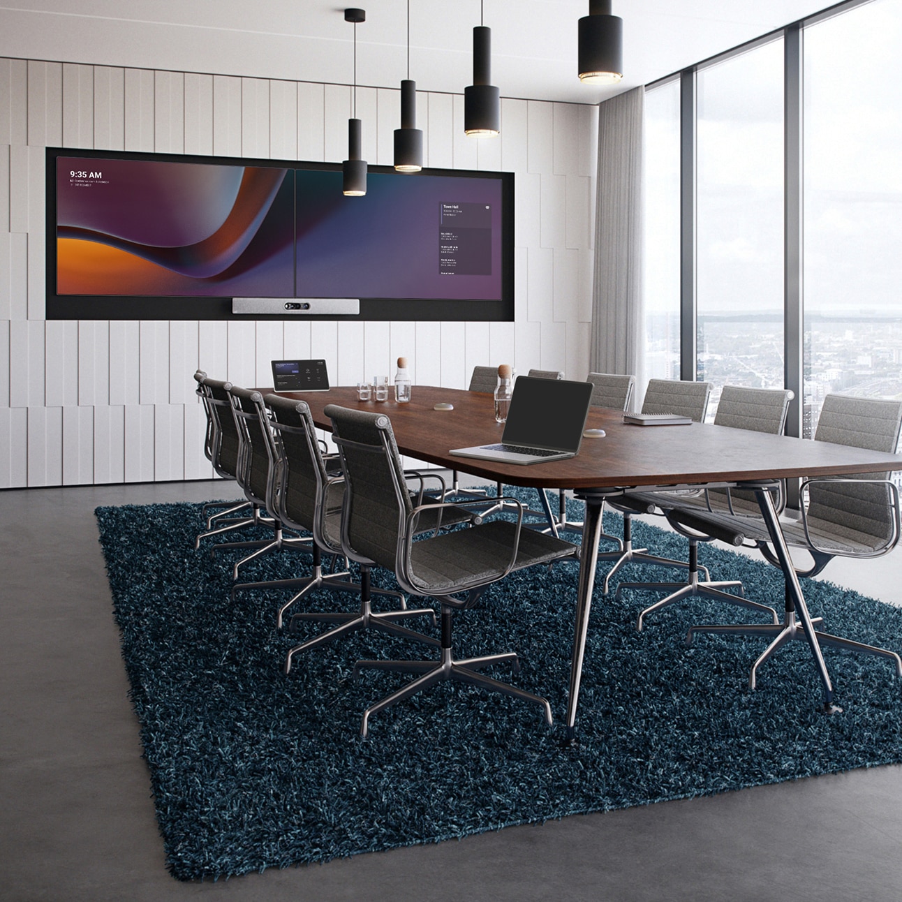 2 台のディスプレイ（Microsoft Teams の UI を表示）に設えた Cisco Room Kit Pro を壁に取り付けている広い会議室。