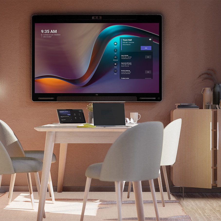 The Cisco Board Pro running in Microsoft Teams Rooms mode shown from the front in a small huddle room with the tabletop Cisco Room Navigator and a laptop.