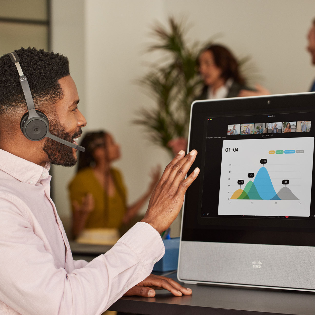 Person takes call from the Cisco Headset 720 Series, using noise removal to avoid background noise from people chatting nearby.