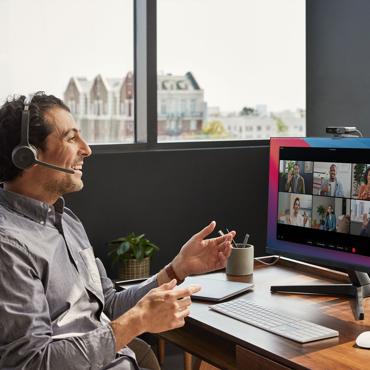 Person takes call from the Cisco Headset 720 Series, using noise removal to avoid background noise from people chatting nearby.