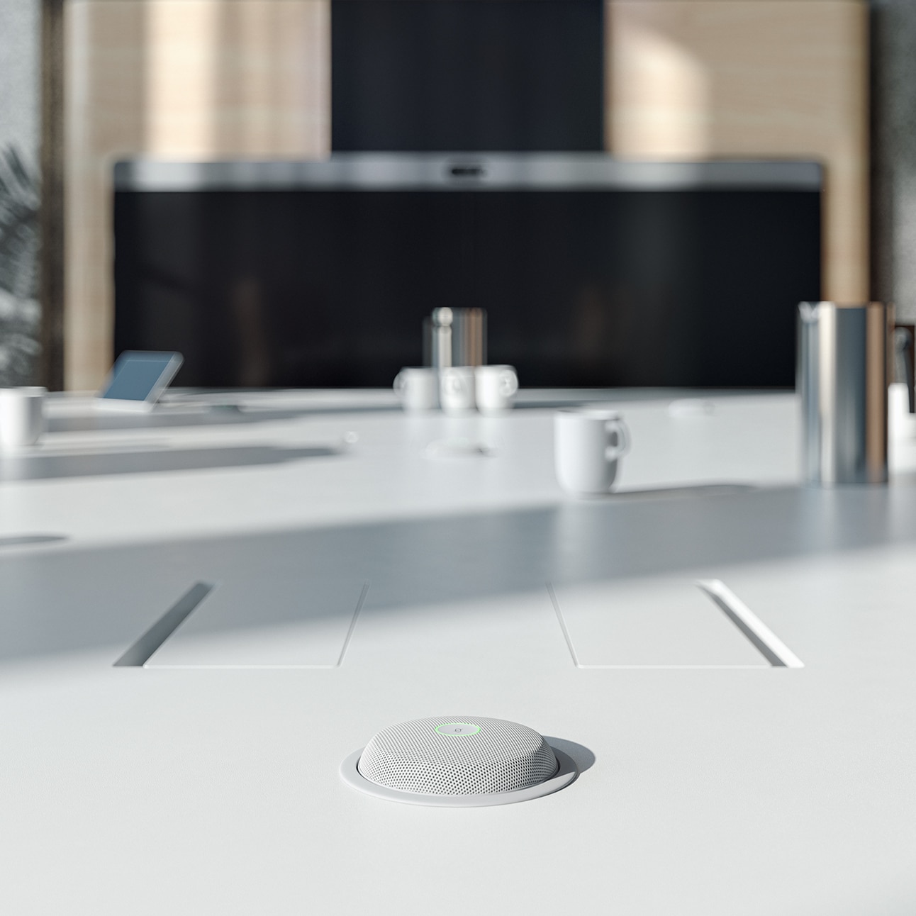 Close-up view of the Cisco Table Microphone Pro recessed into a boardroom table furniture, with the Cisco Room Panorama system visible in the background.