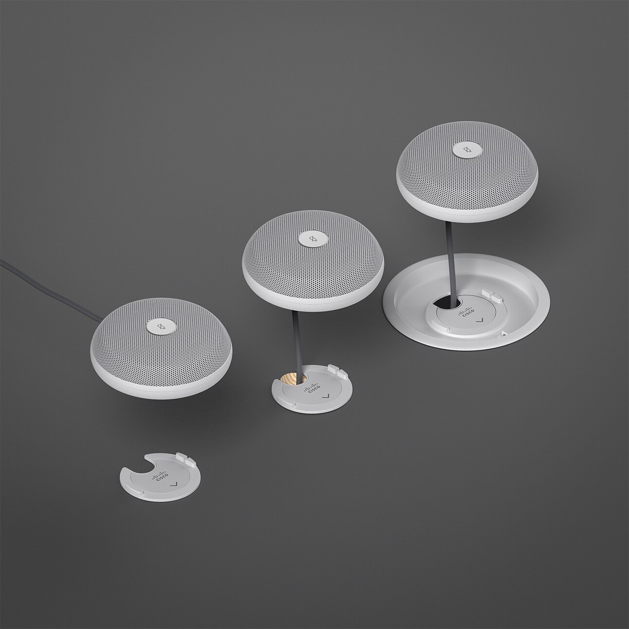 Close-up view of three different mounting options of the Cisco Table Microphone Pro floating above the surface of the table furniture.