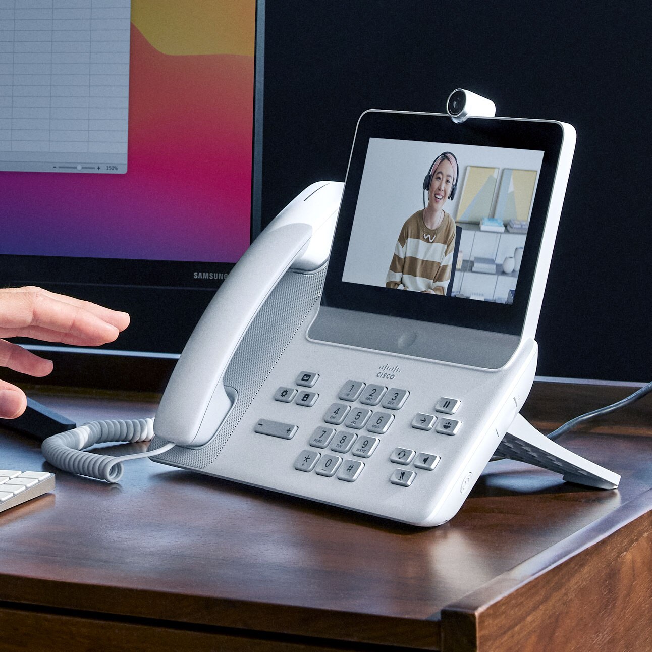 Video meeting in progress on a Cisco Video Phone 8875. Phone's screen shows a colleague who has joined the meeting.