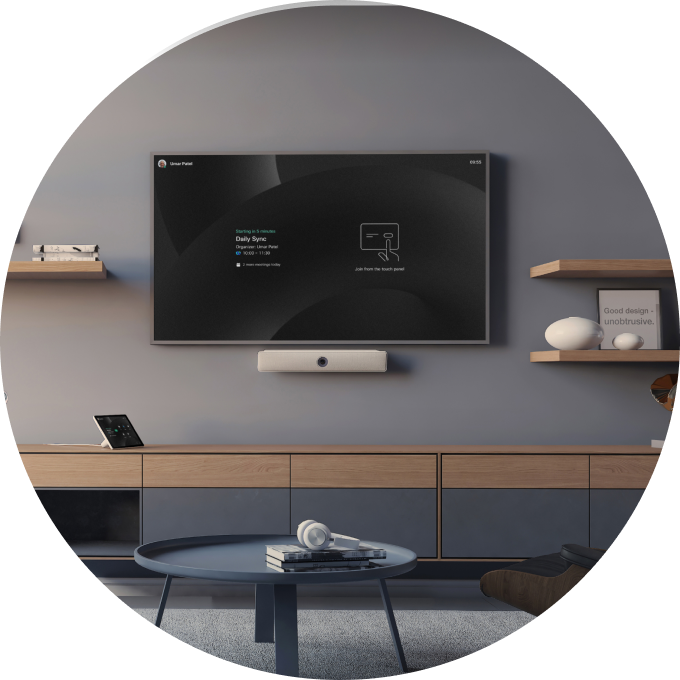 A home workspace featuring the Webex Desk on a desk and the Webex Room Bar mounted on the wall for great video meetings.
