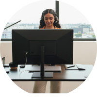 person looking busy at standing desk, shot is taken from behind monitor