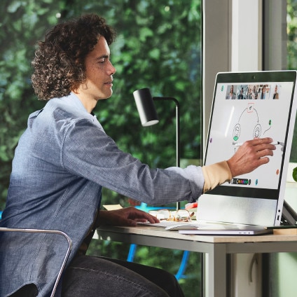 person whiteboarding at desk with a Webex tabletop device