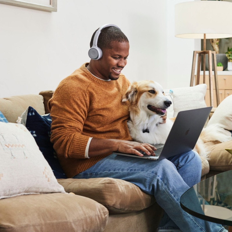 happy looking customer at home using laptop with dog