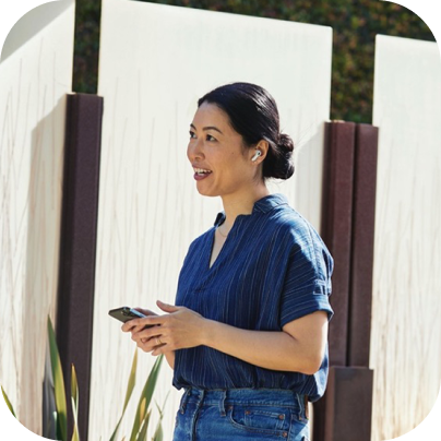 Person standing, using a cellular phone as their small business phone system