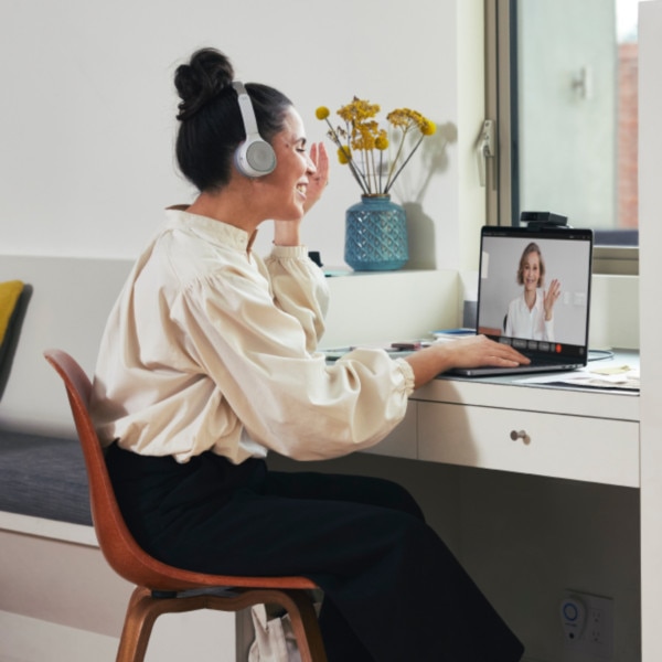 A person seated in a home office engages in an online meeting.