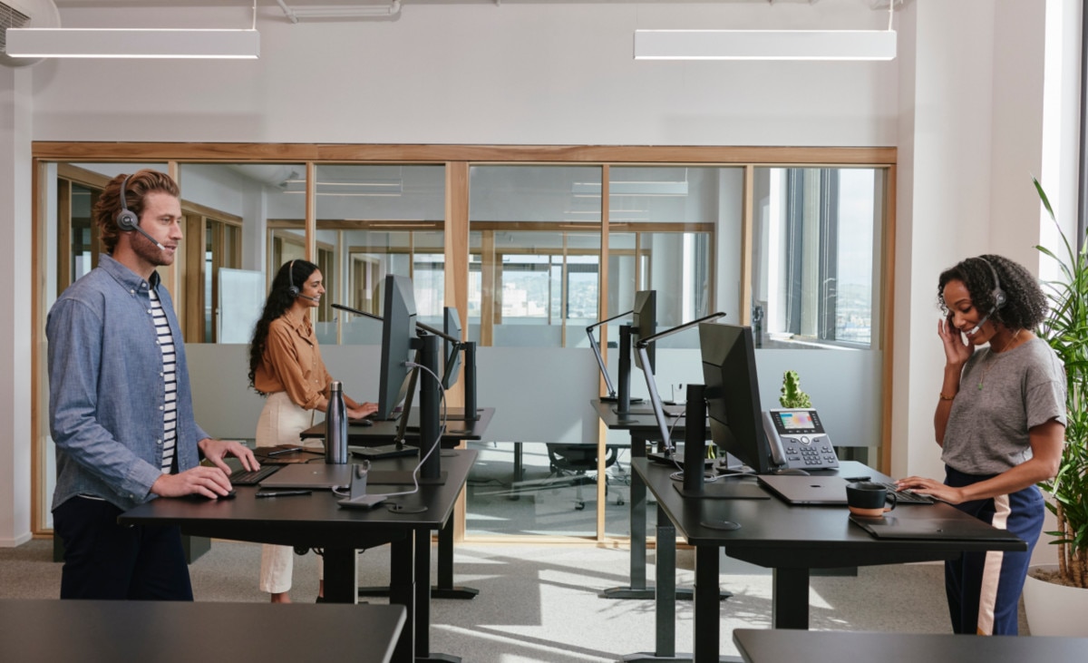 CCaaS in action: a team of three cloud contact center agents work at standing desks