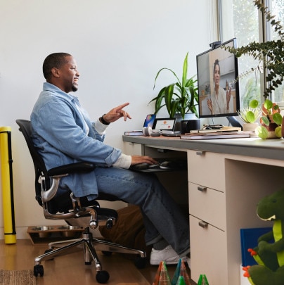 A seated person engages in a video conference