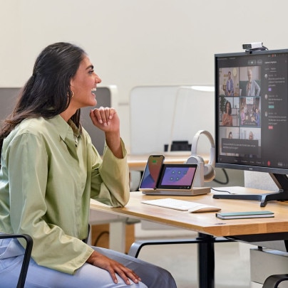 A seated person joins multiple colleagues through video conferencing technology.
