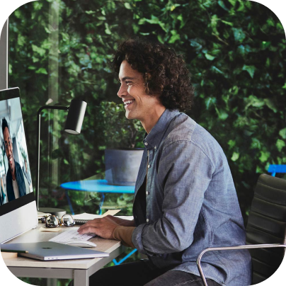 A person sitting at a desk, engaged in a virtual meeting.