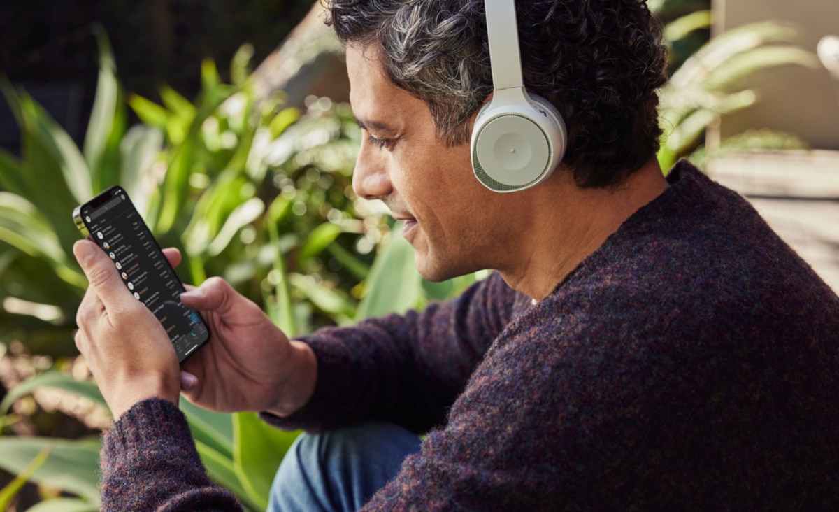 A person wearing a noise-cancelling headset uses VoIP calling technology via a mobile phone.