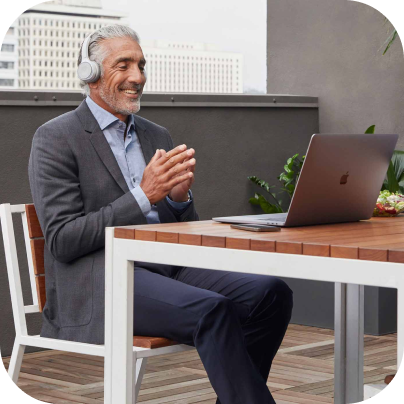 A person wearing noise cancelling headphones uses video conferencing to participate in a virtual meeting.Uma pessoa que usa fones de ouvido que cancelam ruídos usa videoconferência para participar de uma reunião virtual.