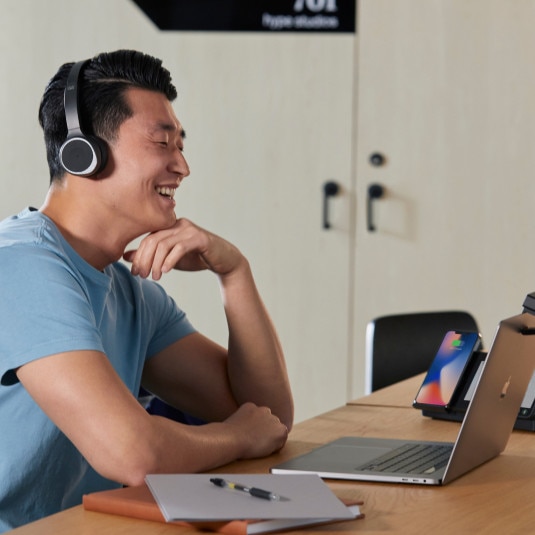 person at desk, working and possibly video conferencing on laptop