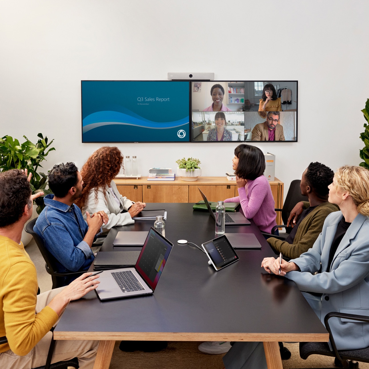 In-office workers video conference with hybrid colleagues using Cisco Room Kit device and Microsoft Teams.