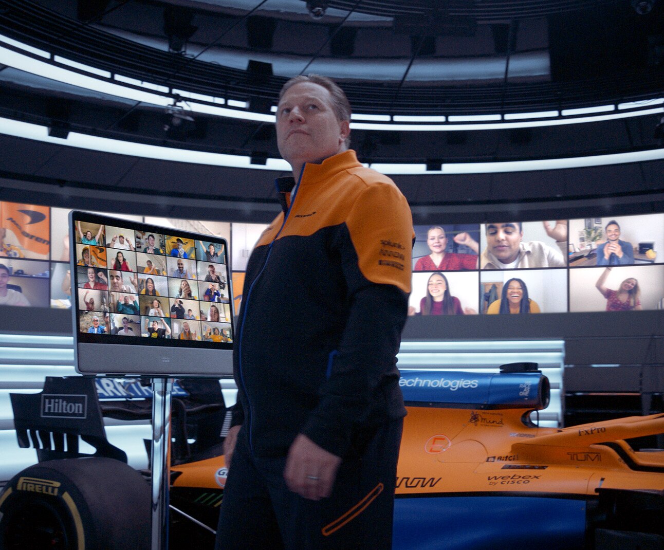 McLaren F1 Racing team member uses Cisco Desk Pro for Webex video conference in grid view inside McLaren HQ.