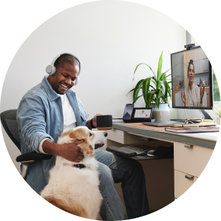 Person looking relaxed with dog while working/conferencing on desktop device