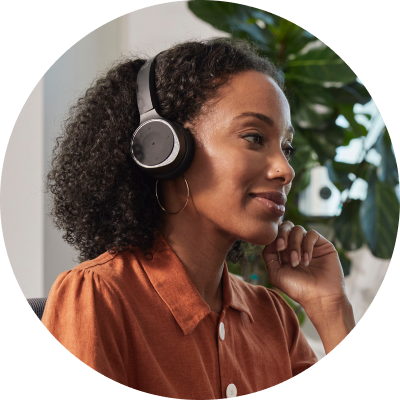 person looking busy at desk, wearing headphones and presumably on a call