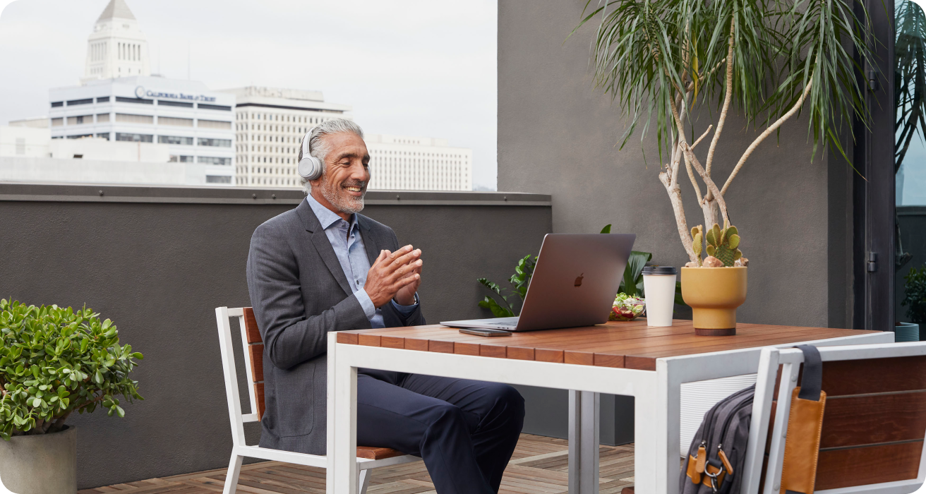 Business person in an office collaborates via a Webex meeting from a laptop