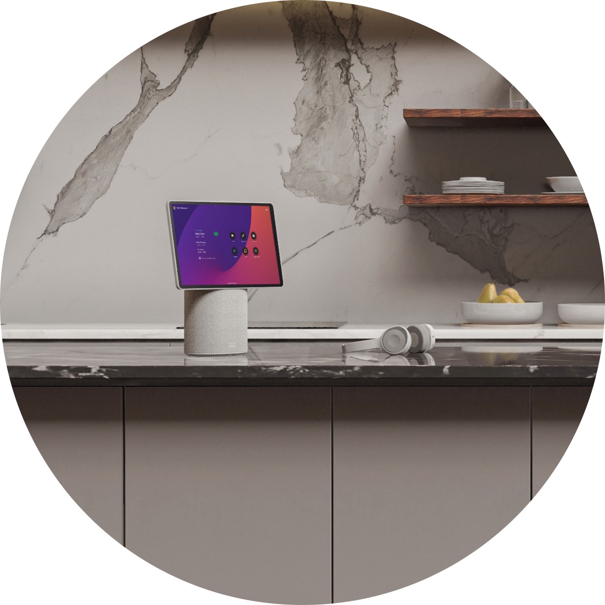 A Cisco Desk Mini and a headset rest on the counter of a modern kitchen, replete with faux marble surfaces and minimalist cabinetry.