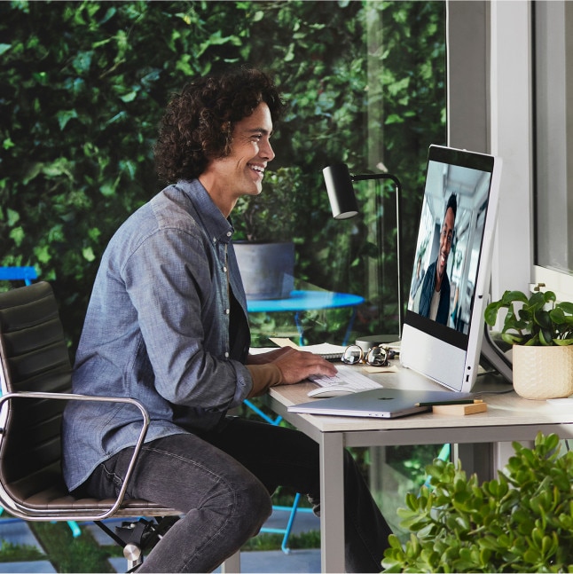 Person collaborates with a colleague via Webex Calling on a Webex Desk Pro in the office.