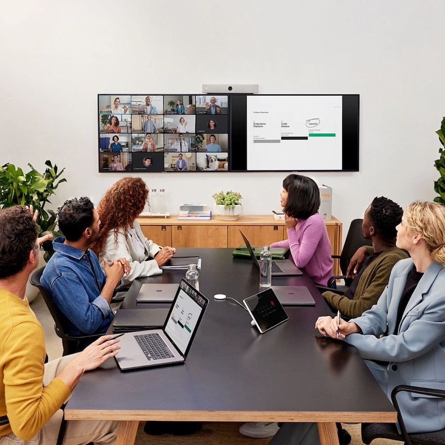 会議室にいる 6 人の同僚が、リモートの複数の同僚と Webex でビデオ会議を行っている