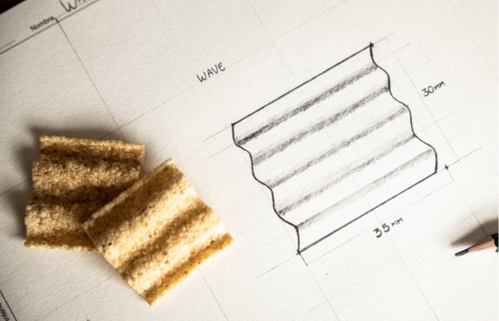 Two chips next to a pencil drawing of the same type of chips with the dimensions 35mm by 30mm specified.