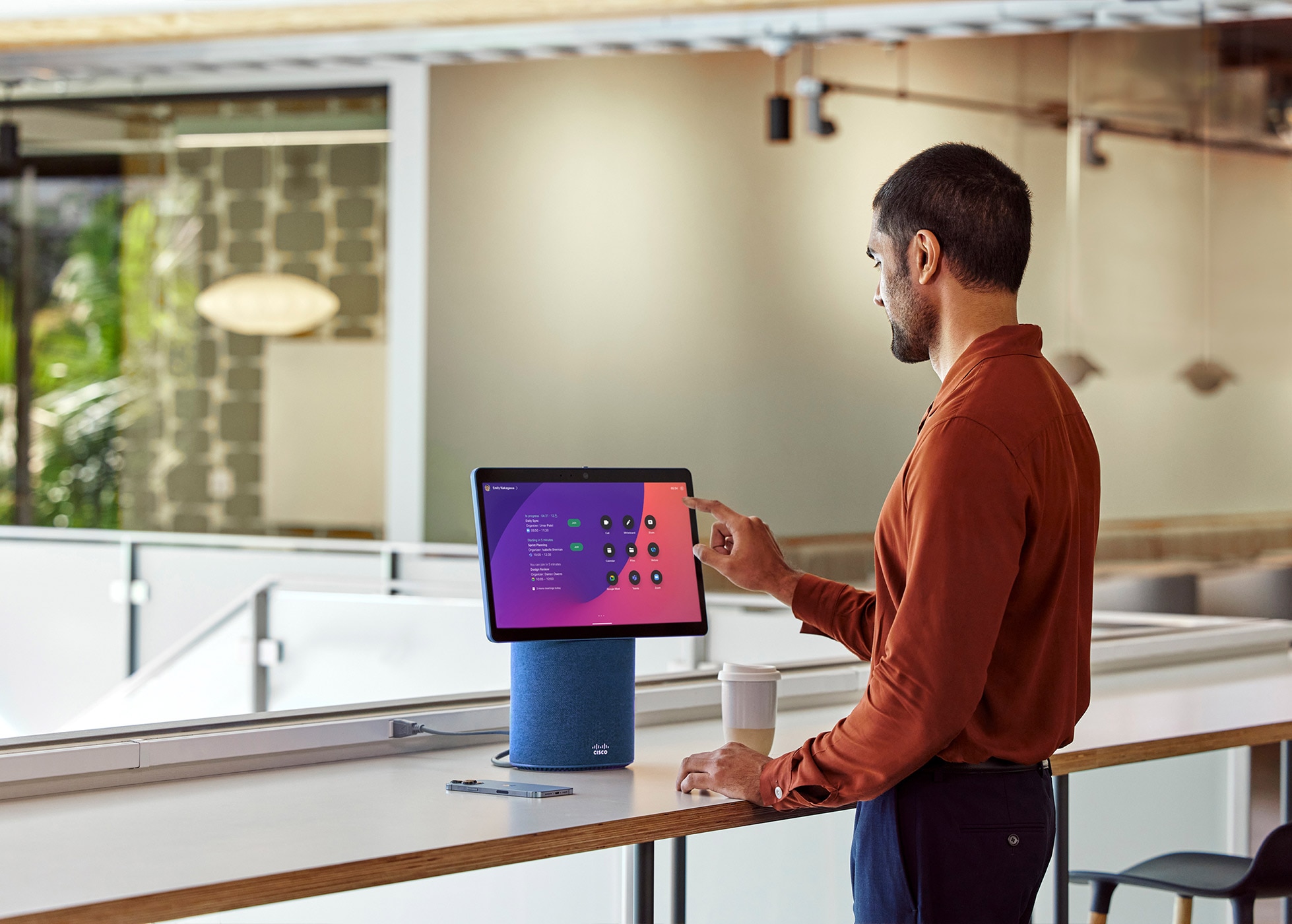 Person taps Webex Desk Mini’s touch screen to join Zoom meeting. Screen shows apps like Google Meet, Microsoft Teams, and Zoom